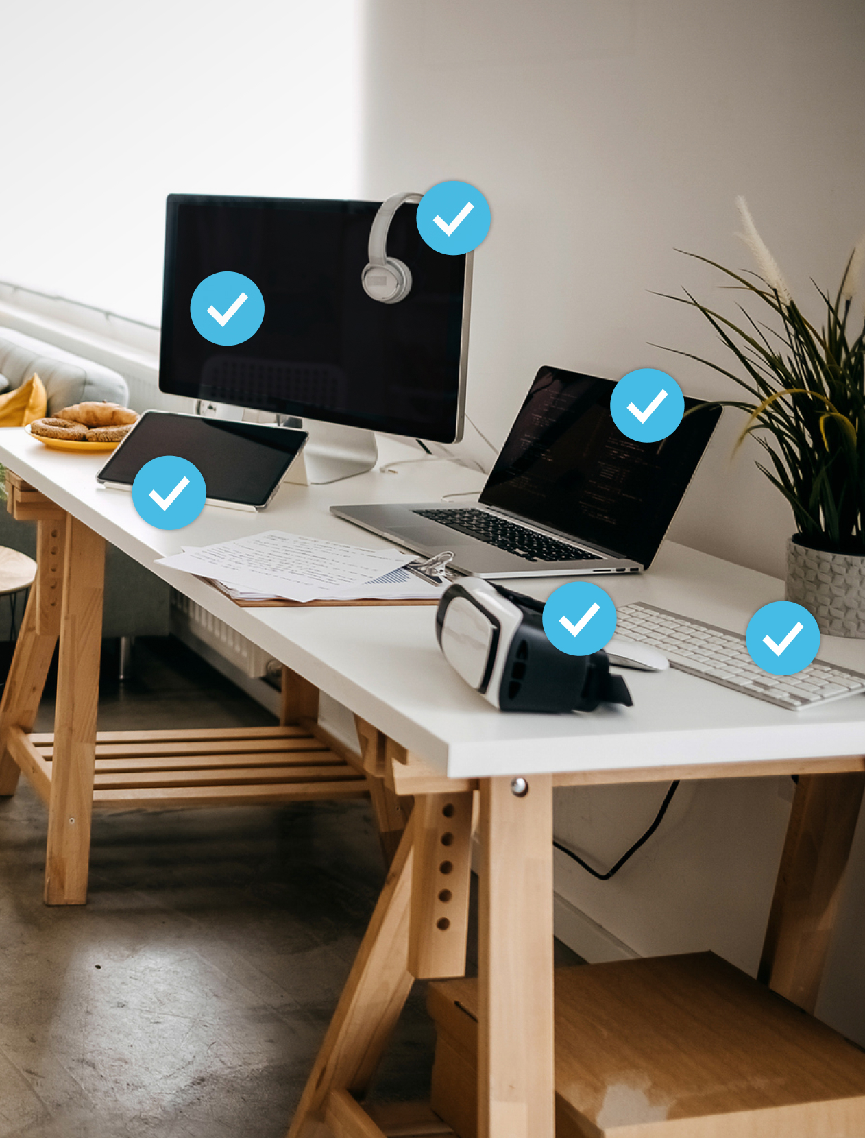 Desk with laptop, desktop computer, headphones, tablet, keyboard and VR headset on top