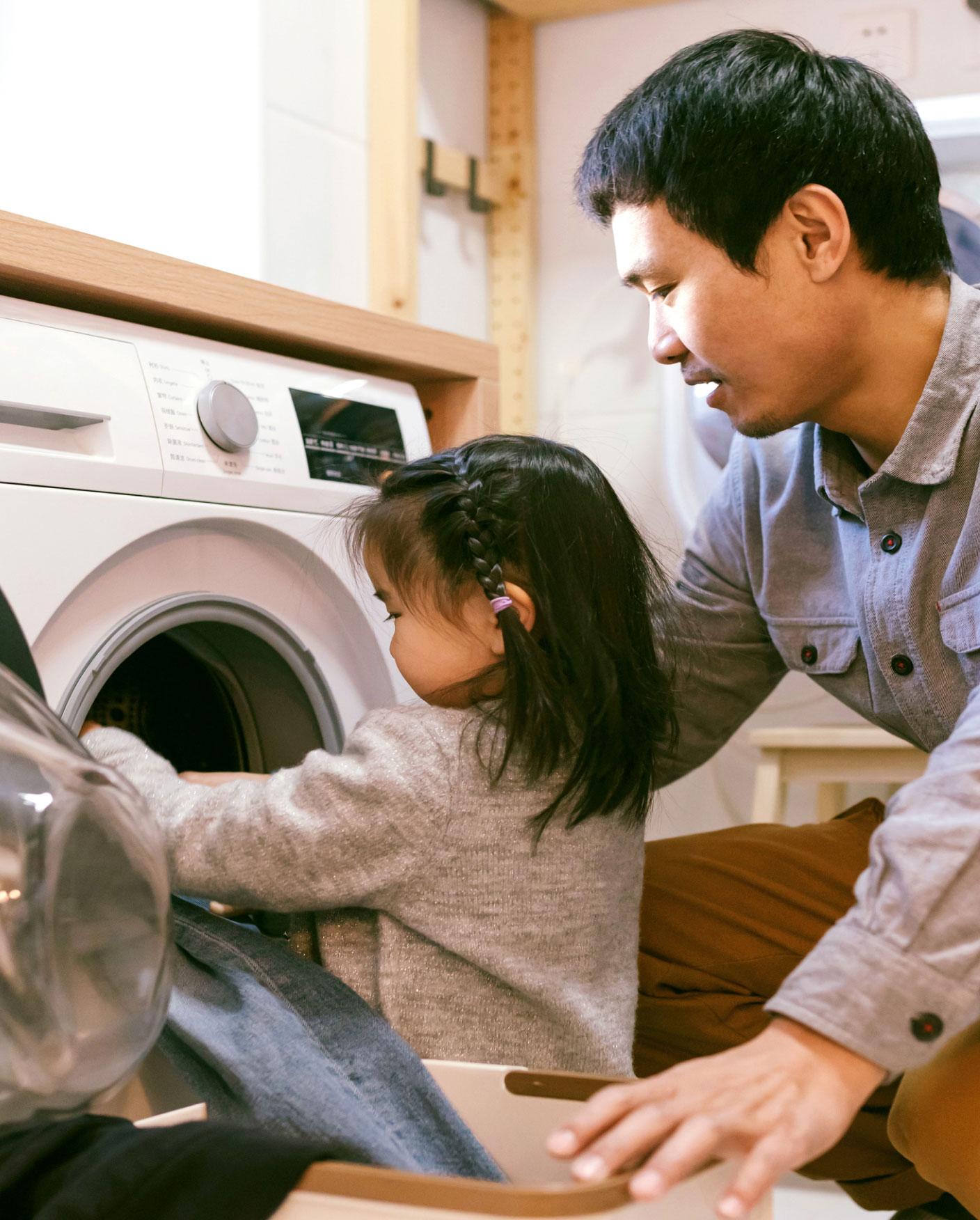 man and daughter doing laundry