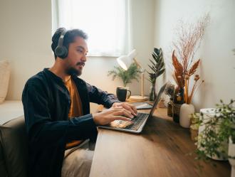 man wearing headphones on laptop
