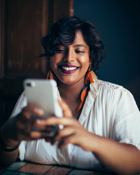 woman smiling looking at smartphone