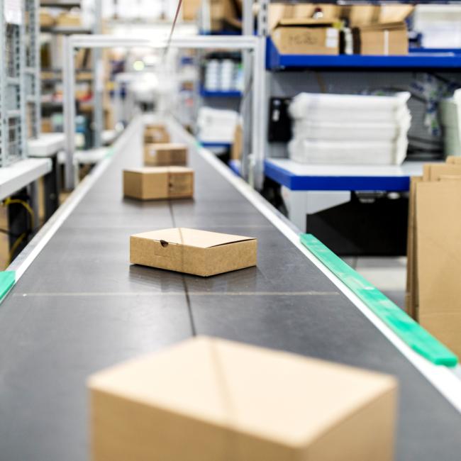 Cardboard boxes move along service center conveyor belt
